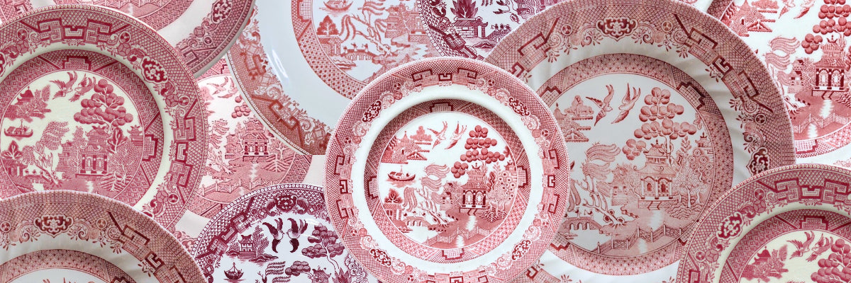 Photo collage of vintage Red Willow china plates showcasing the classic Blue Willow pattern reimagined in striking crimson hues, transforming the traditional blue and white design into rich red transferware.