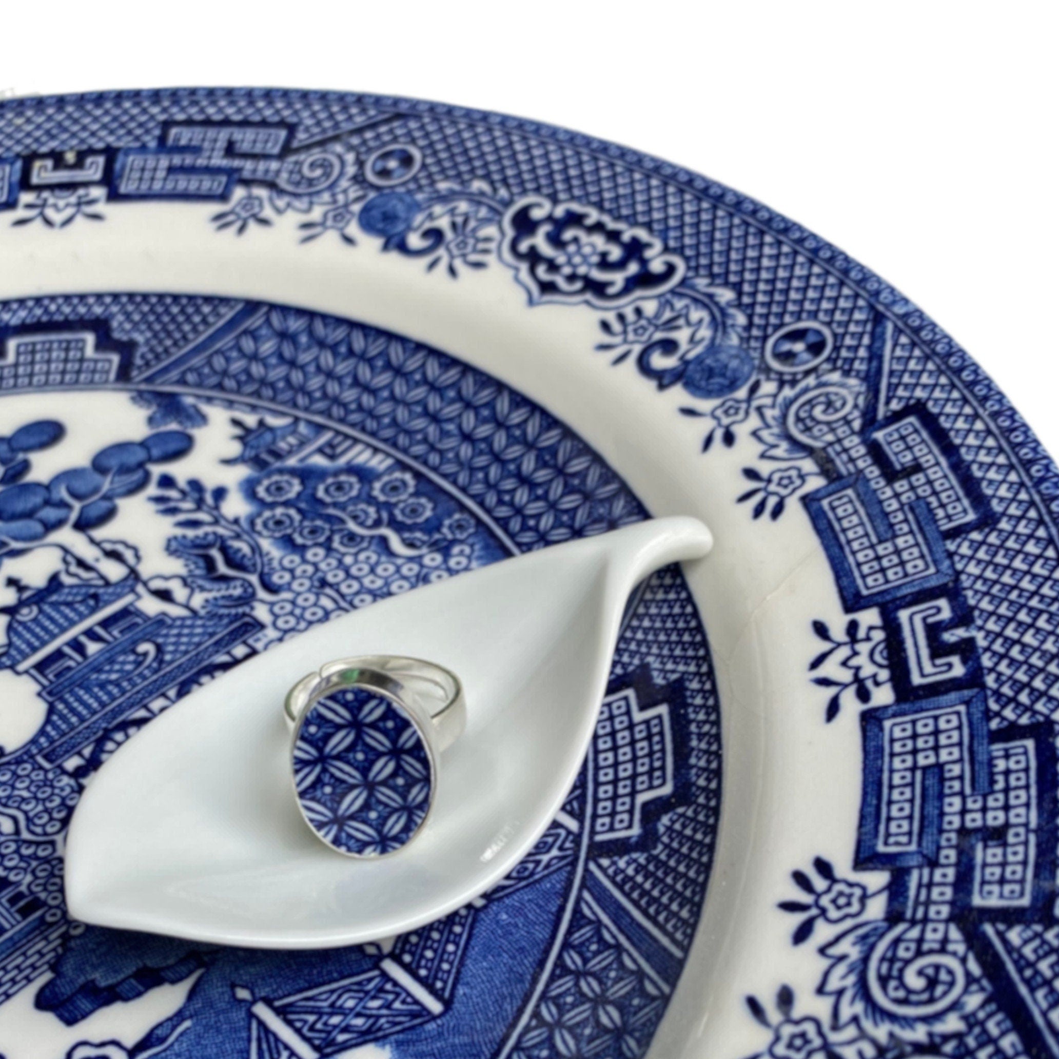 Vintage Churchill Blue Willow china set in an adjustable sterling silver ring setting, in an oval shape, and displayed on the same style plate it originates from