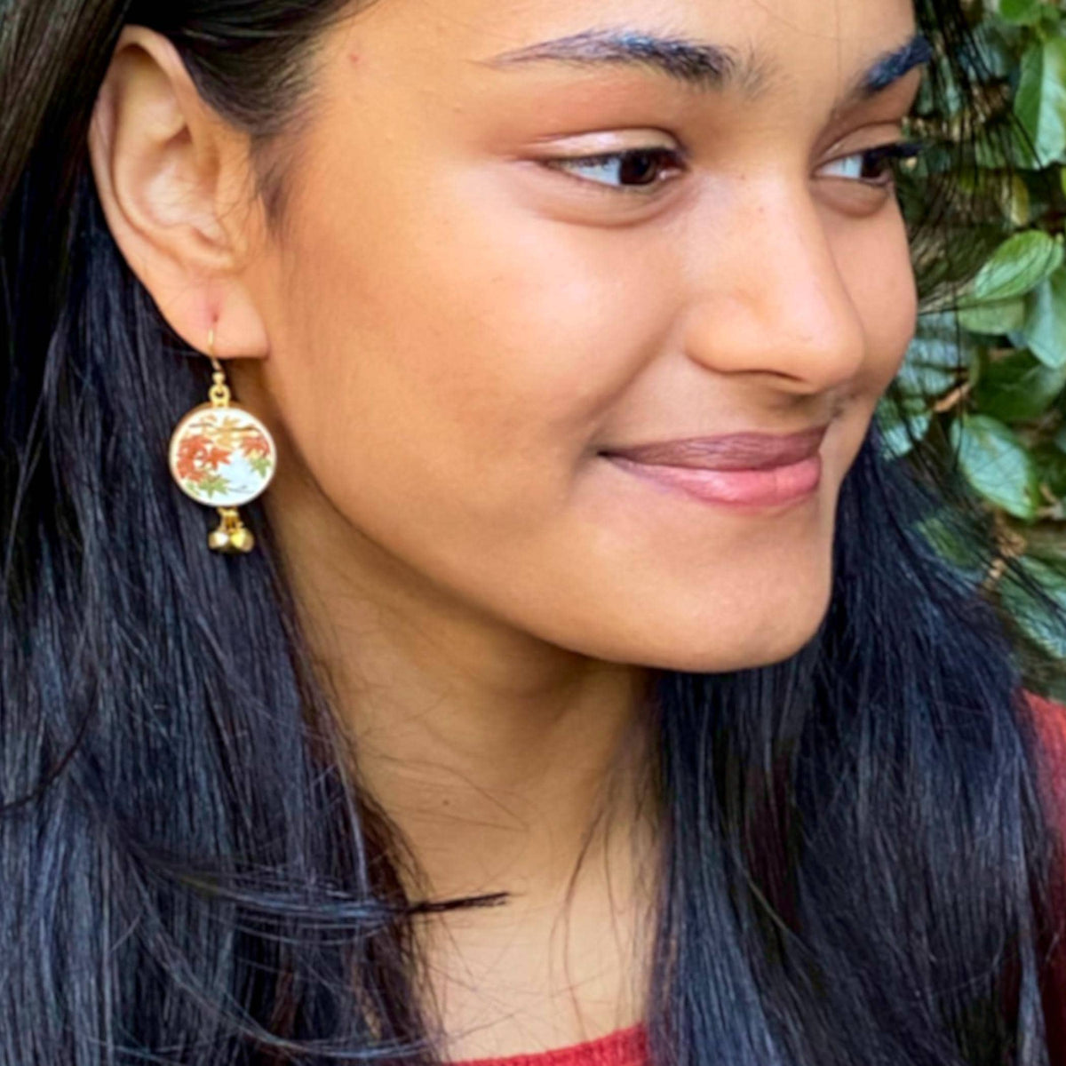Model wearing a Fall maple leaf matching earrings made from upcycled Japanese Imari porcelain.