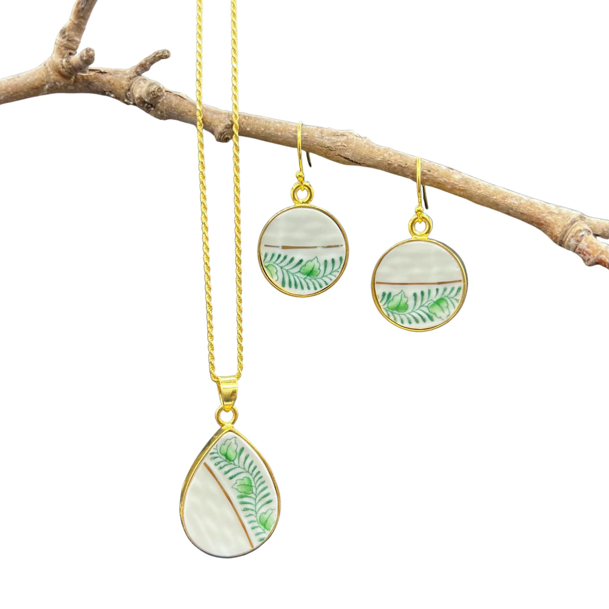 Herend Chinese Bouquet porcelain necklace and earrings hanging on a branch, showing the gold plated sterling silver bezels and chain.