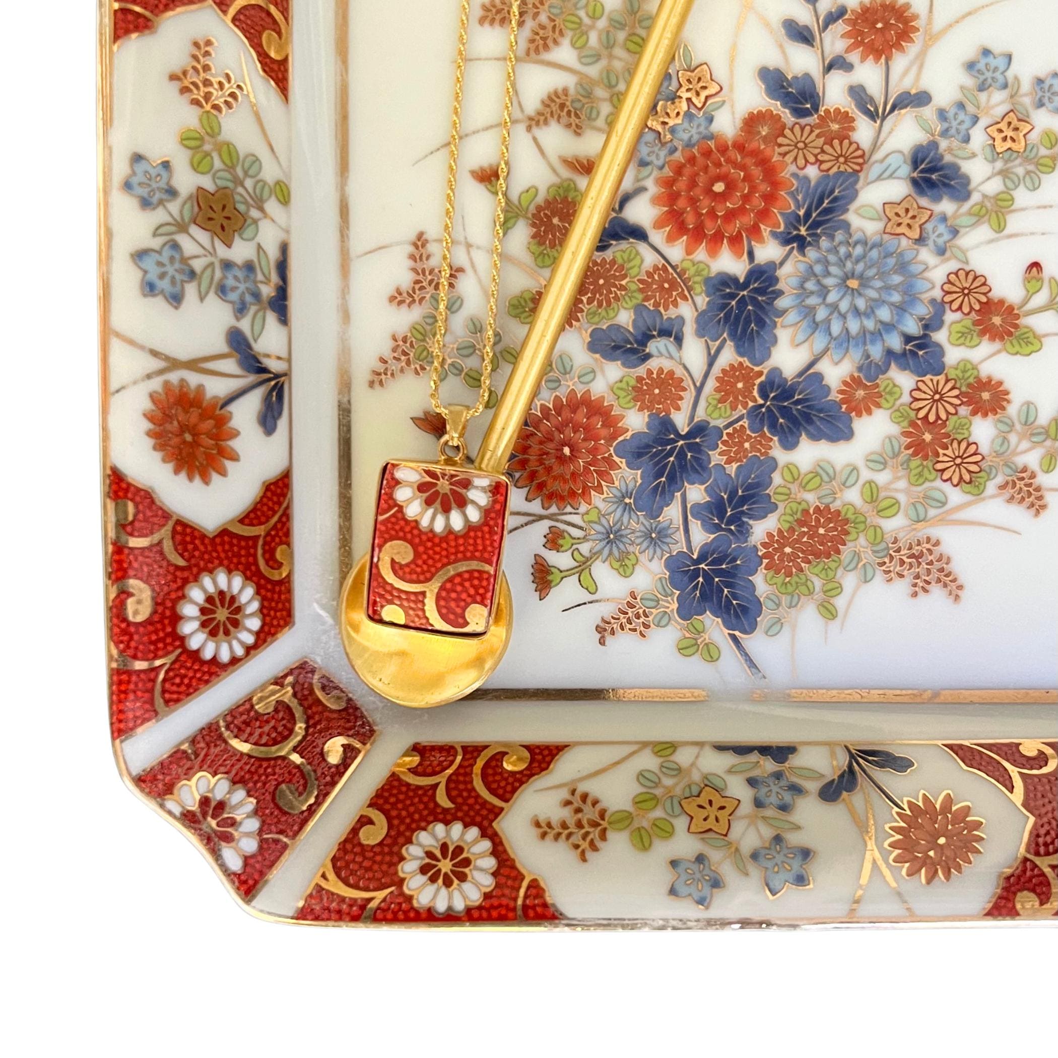 Handcrafted gold-plated pendant featuring upcycled Japanese Kutani porcelain with vibrant orange and gold floral design