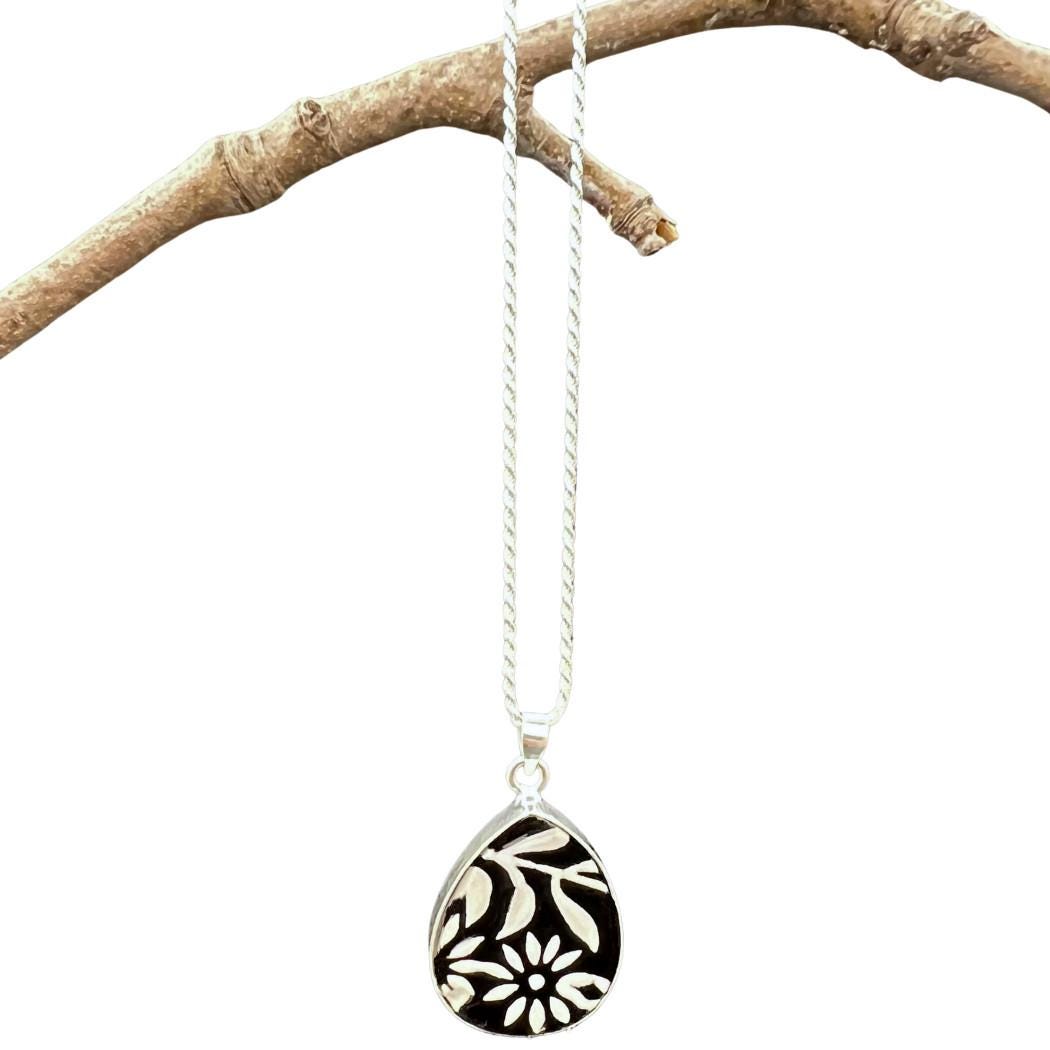 Elegant black and white flower ceramic pendant on a sterling silver rope chain.