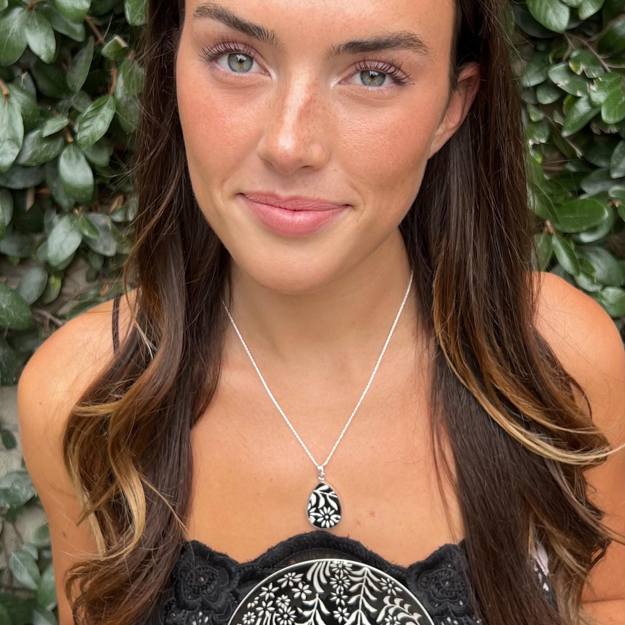 Model wearing handmade broken china jewelry necklace with black and white floral design.