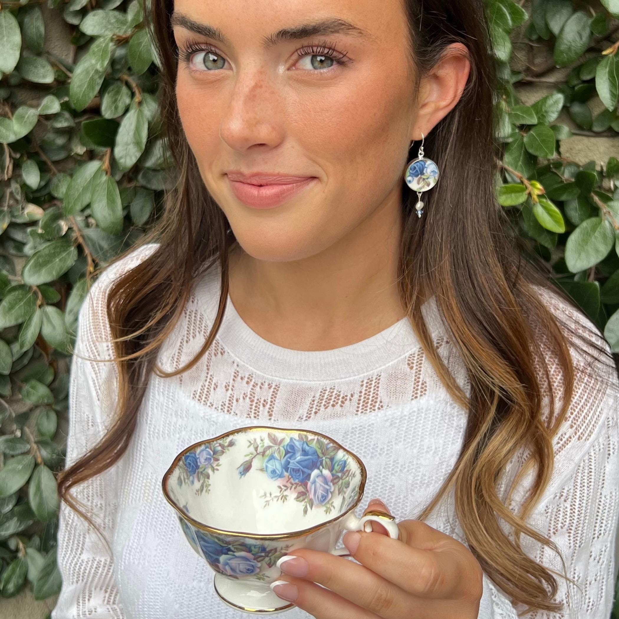 Model wearing blue rose broken china jewelry earrings made from vintage Royal Albert Moonlight Rose china in sterling silver settings
