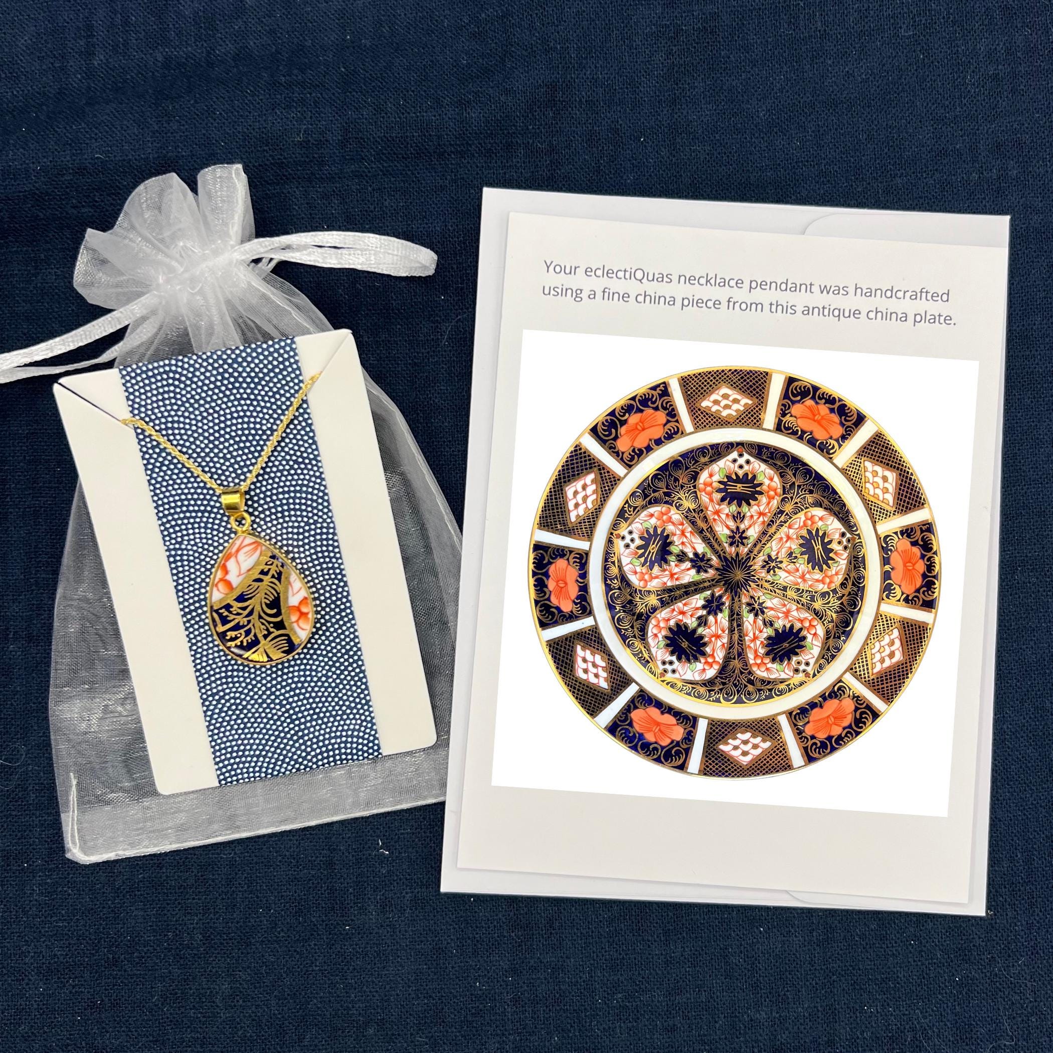Royal Crown Derby Old Imari pendant necklace on a white organza jewelry bag with a photo card of the source china plate.
