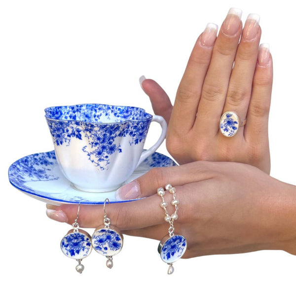 Shelley Dainty Blue tea cup and saucer, coupled with matching china jewelry including a ring, earrings, and a rosary pearl necklace with sterling silver and pendant.