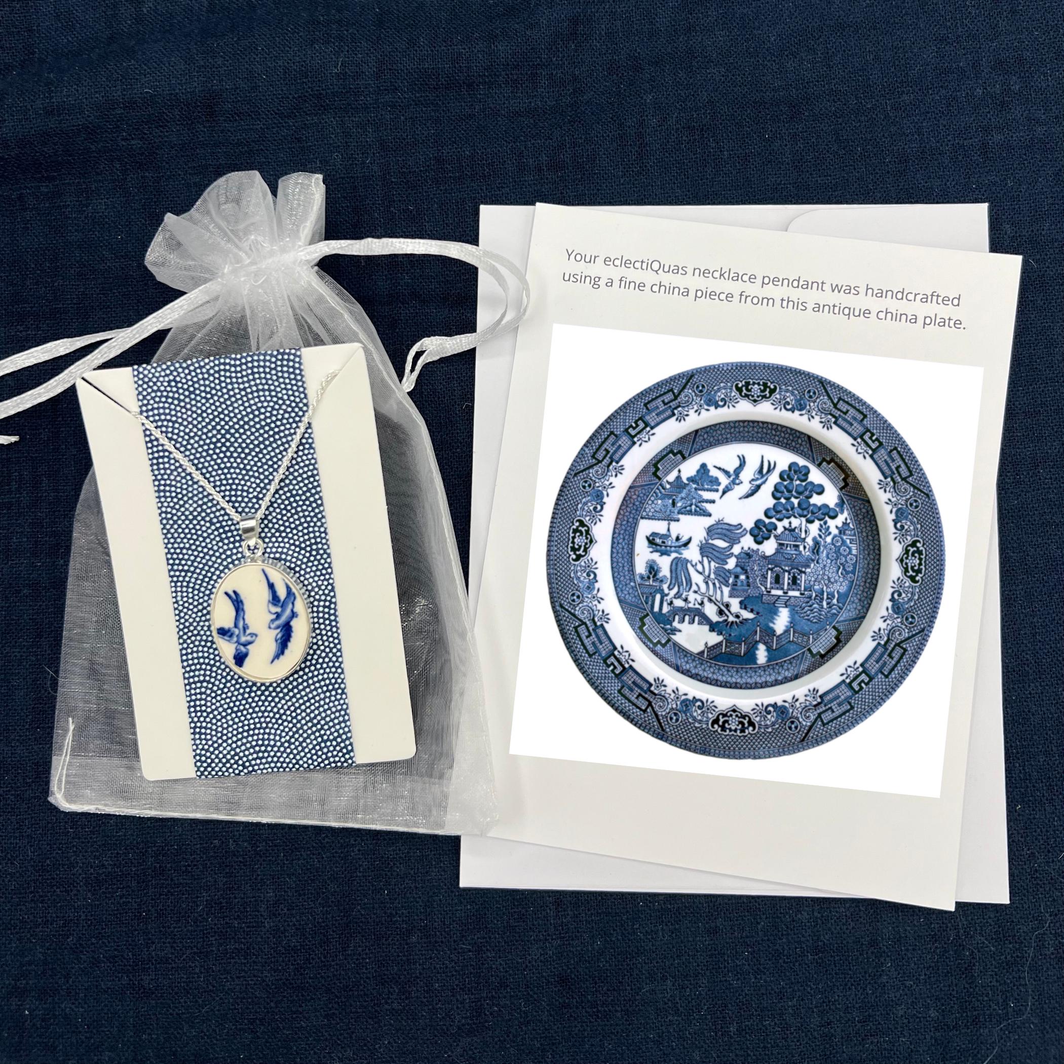 Blue Willow Love Birds necklace (oval) on a white organza jewelry bag with a photo card of the china plate it was made from.