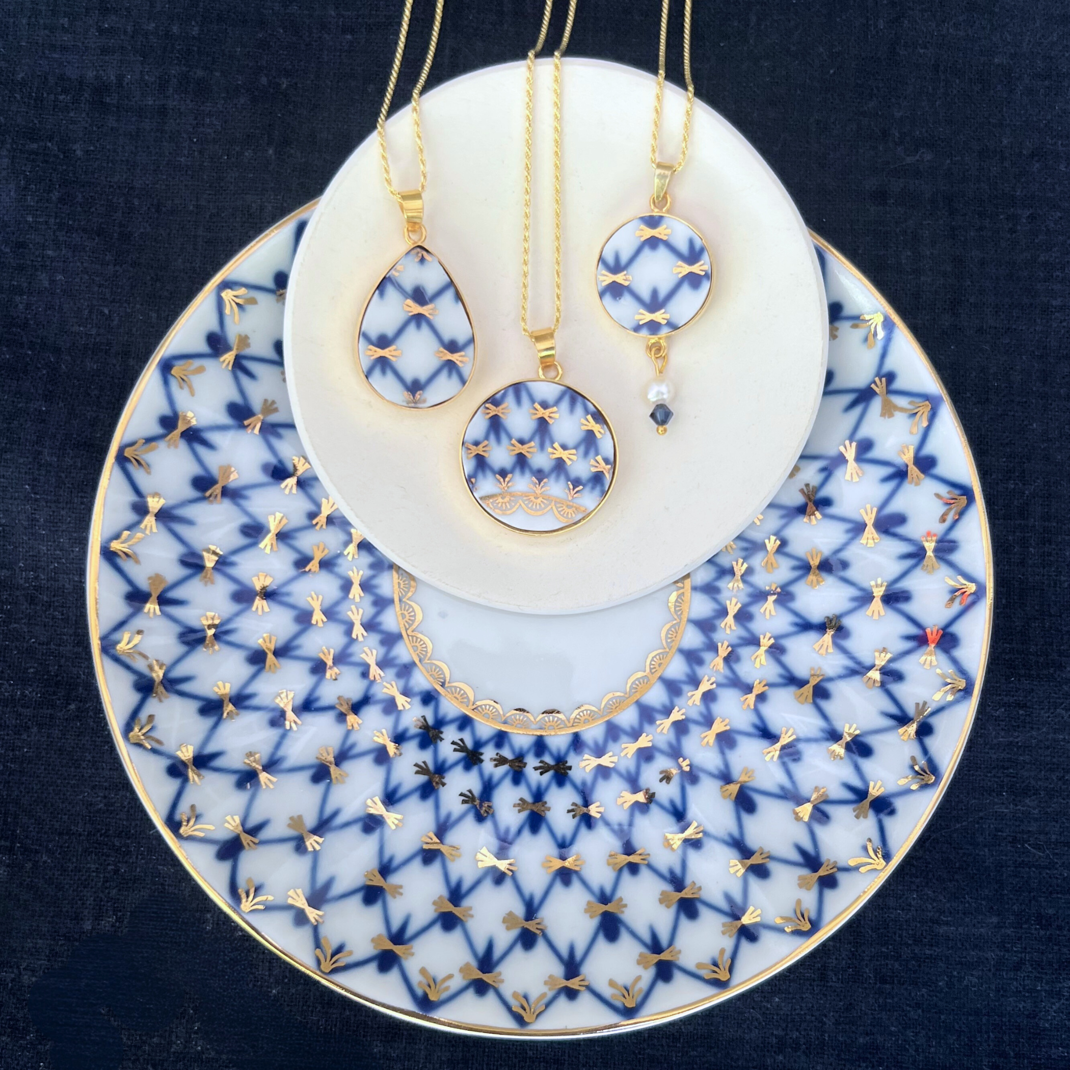 Close-up of handcrafted Lomonosov Cobalt Net porcelain necklace pendant in gold-plated sterling silver setting