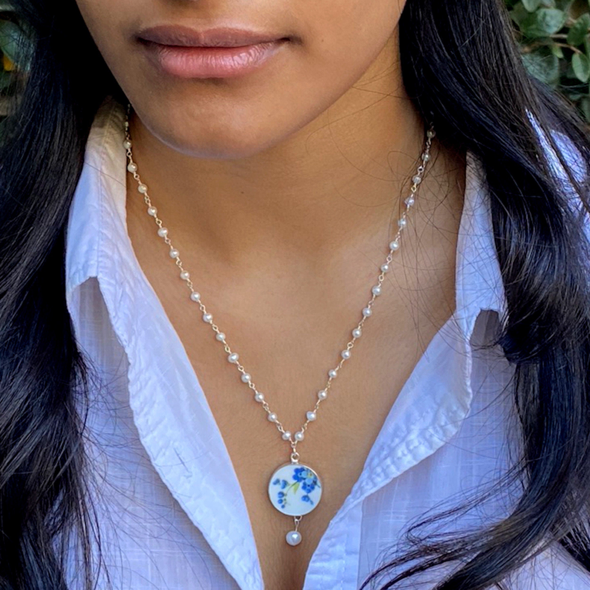 Model showing how to wear this Forget Me Not Broken China Necklace with Tiny Pearl Chain and Blue Flower Pendant.