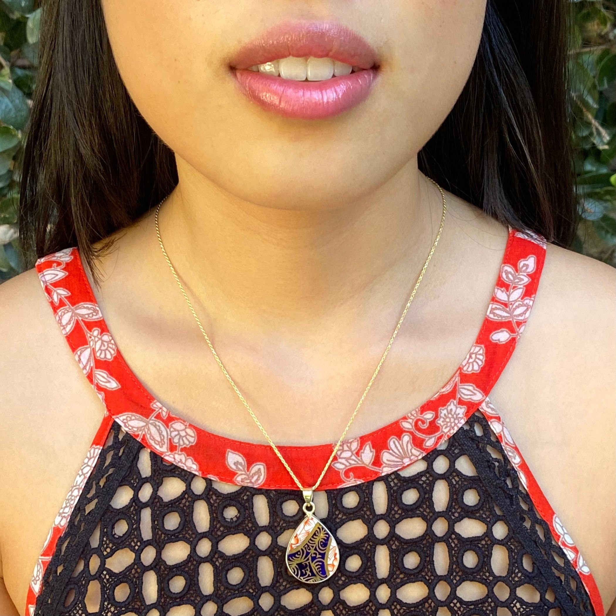 Model wearing the Royal Crown Derby Old Imari teardrop pendant necklace on a gold plated sterling silver rope chain.