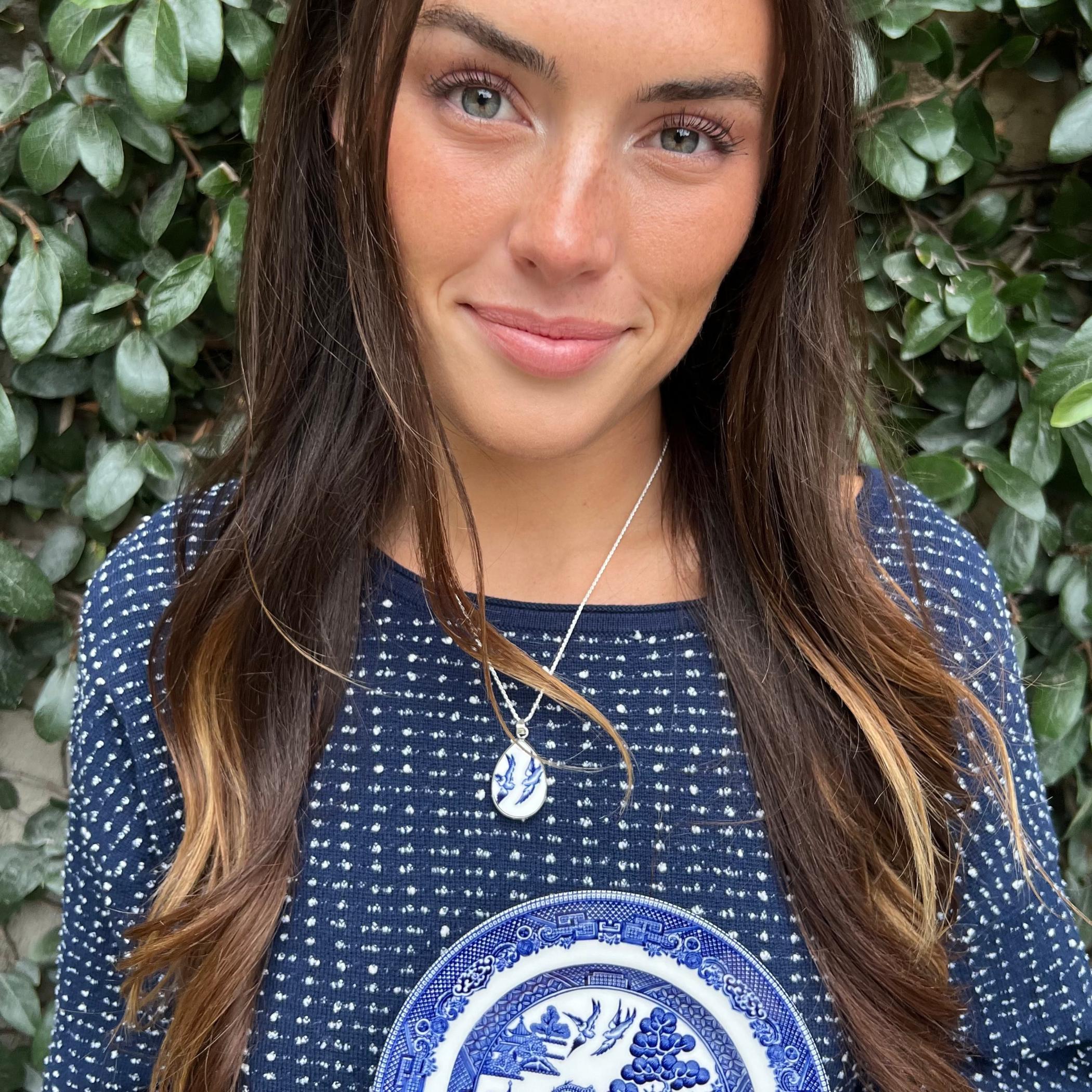 Blue Willow Love Birds necklace worn at the collarbone, showing the teardrop shaped pendant in sterling silver