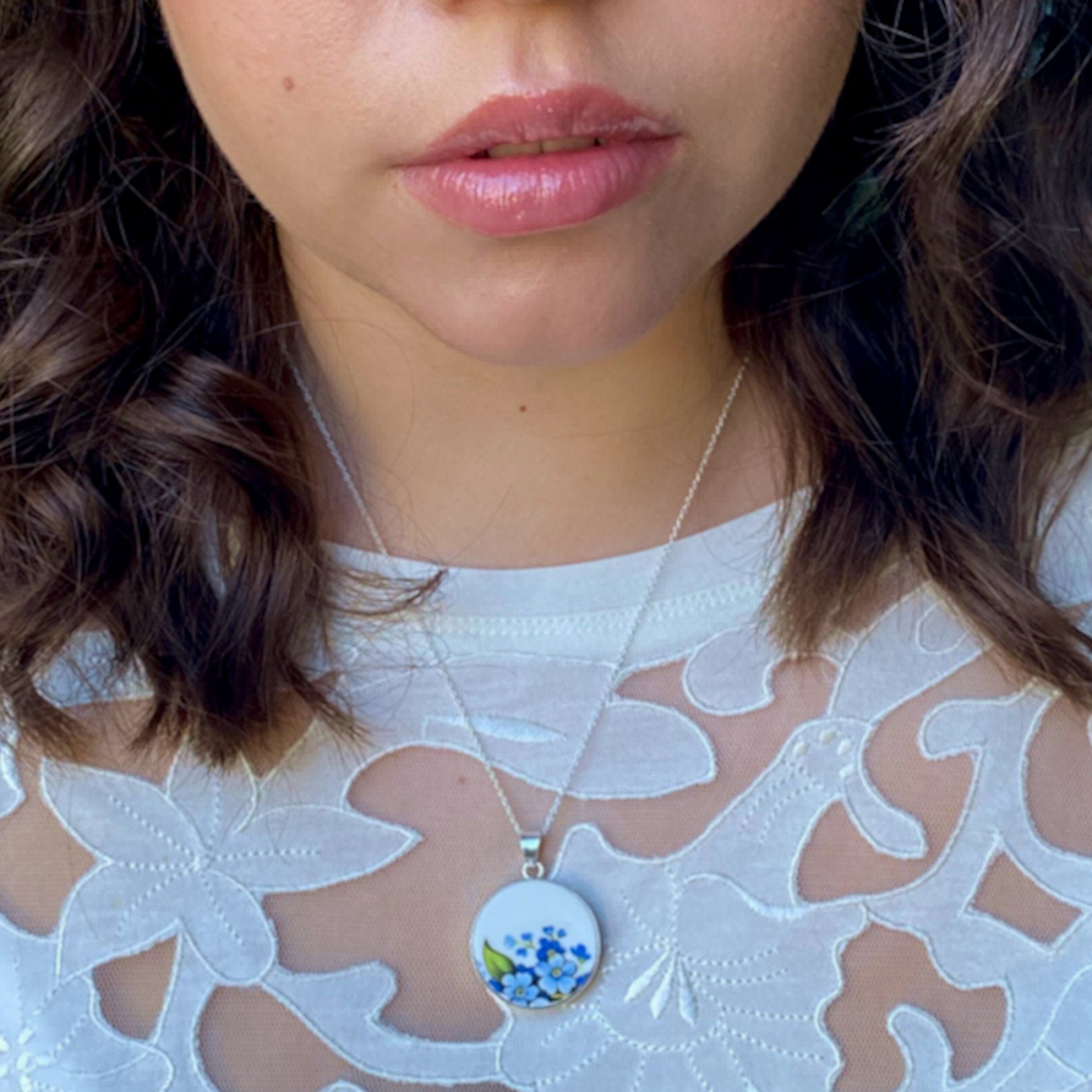 Model wearing this forget me not broken china Nnecklace with tiny pearl chain and a blue flower china pendant.